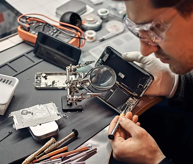 Experienced URPhone Store technician inspecting a phone's internals with a magnifier in Orlando