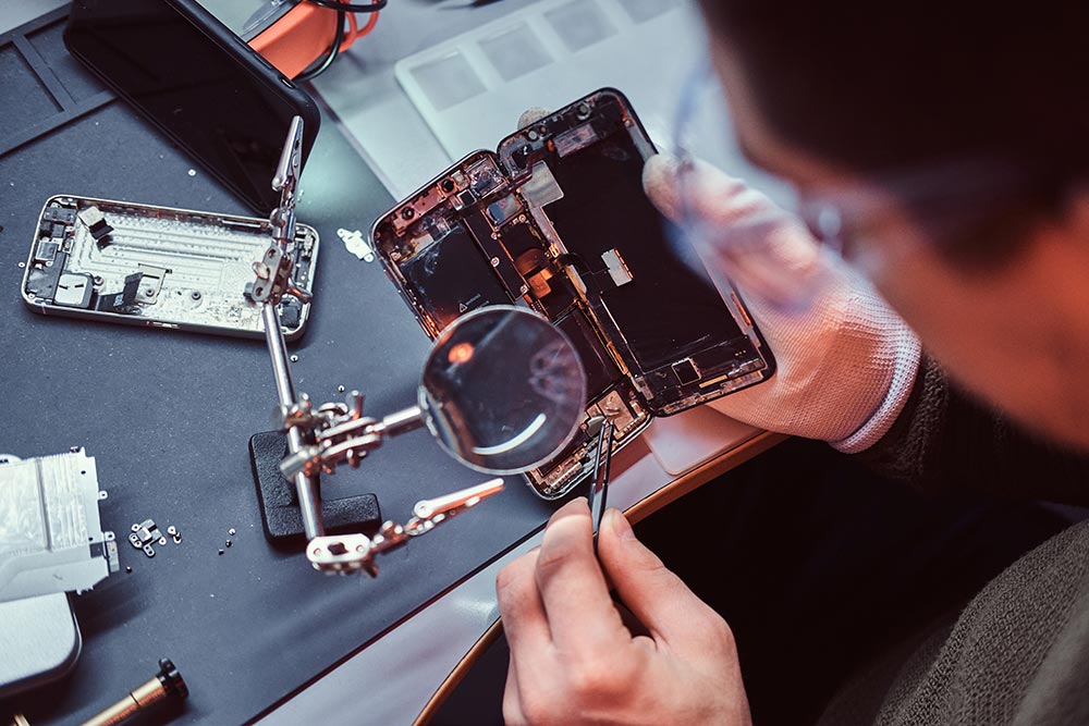 URPhone Store technician repairing a smartphone at the workbench in Orlando